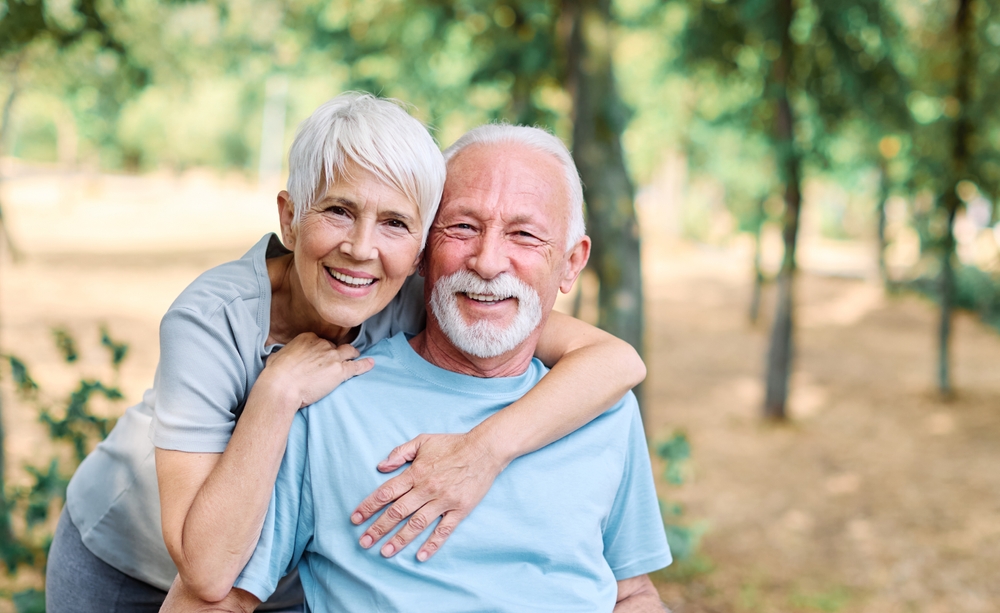 An older couple smiling together outdoors